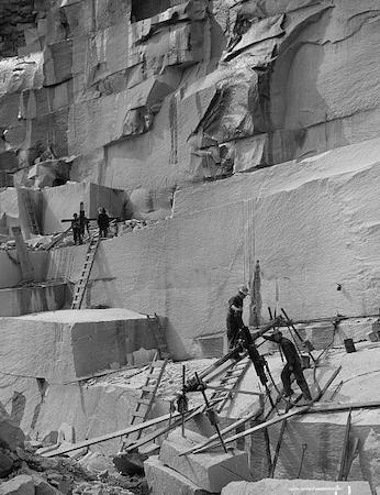 c.1908 photo of granite quarry with men on unsecured wooden ladders running channeling machinery